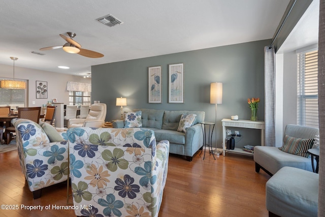 living room featuring wood-type flooring and ceiling fan