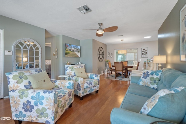 living room featuring ceiling fan and hardwood / wood-style floors