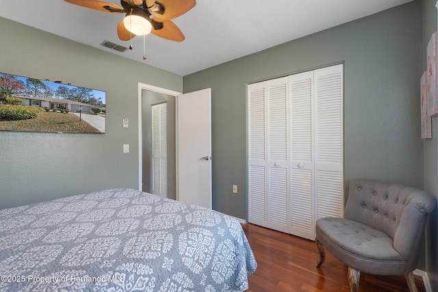 bedroom featuring dark wood-type flooring, a closet, and ceiling fan