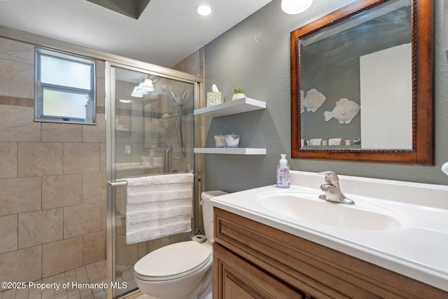 bathroom with vanity, a shower with shower door, and toilet