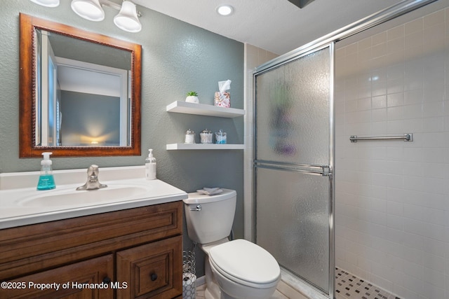 bathroom with vanity, toilet, and a shower with shower door