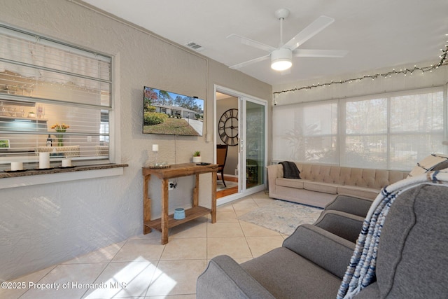 living room featuring light tile patterned floors and ceiling fan