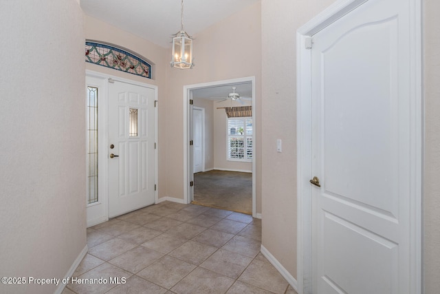 tiled foyer with a chandelier