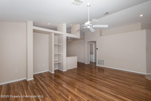 unfurnished living room with lofted ceiling, dark wood-type flooring, ceiling fan, and built in shelves