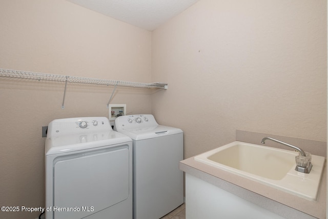 washroom with sink and washer and dryer