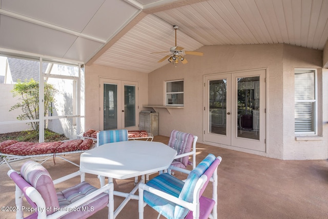 sunroom / solarium featuring lofted ceiling, wooden ceiling, french doors, and ceiling fan