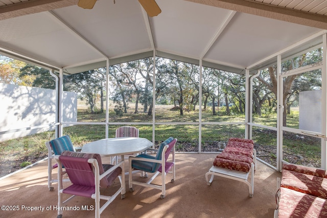 sunroom / solarium featuring ceiling fan, a healthy amount of sunlight, and vaulted ceiling