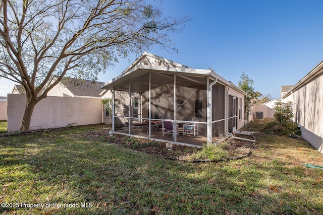 rear view of house featuring a patio, a sunroom, and a lawn