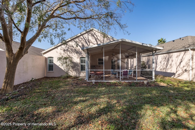 back of house with a yard, a patio area, and a sunroom