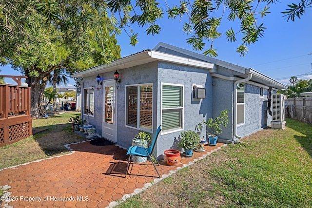 exterior space featuring a yard and a wall mounted AC