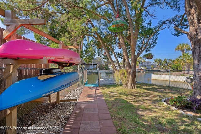 view of yard with a water view and a boat dock