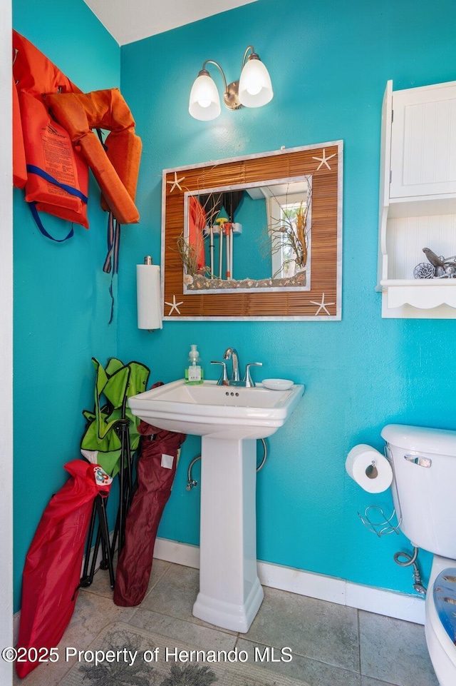 bathroom featuring toilet and tile patterned flooring