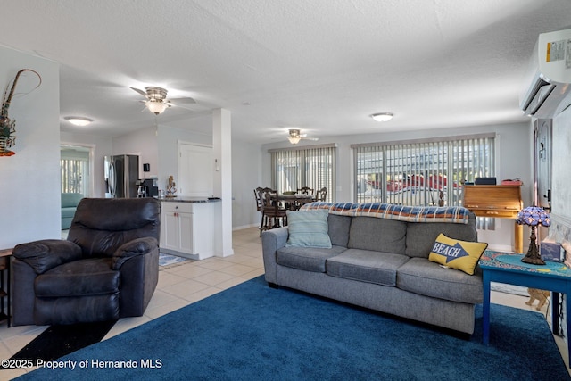 tiled living room featuring ceiling fan, a wall unit AC, and a textured ceiling