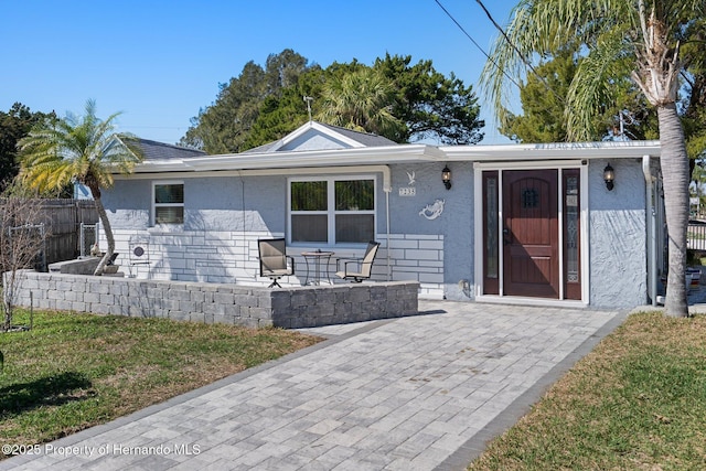 single story home featuring a patio area and a front lawn