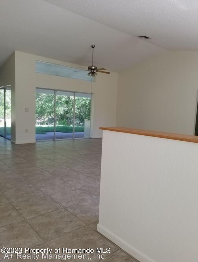 tiled spare room featuring lofted ceiling and ceiling fan