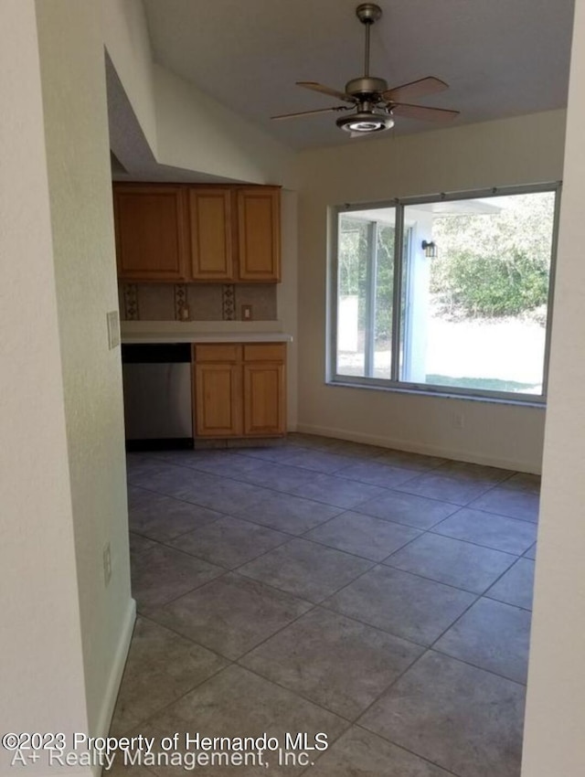 kitchen featuring ceiling fan, vaulted ceiling, and light tile patterned floors