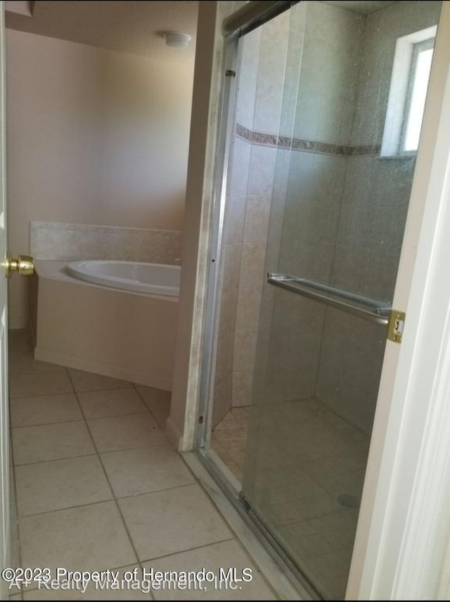 bathroom featuring shower with separate bathtub and tile patterned flooring