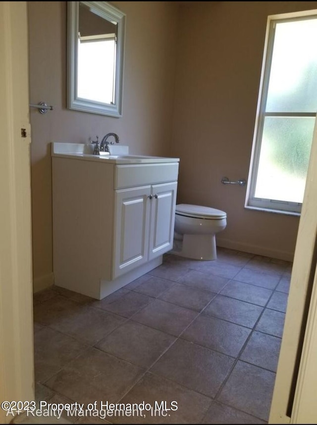 bathroom featuring toilet, tile patterned flooring, and sink