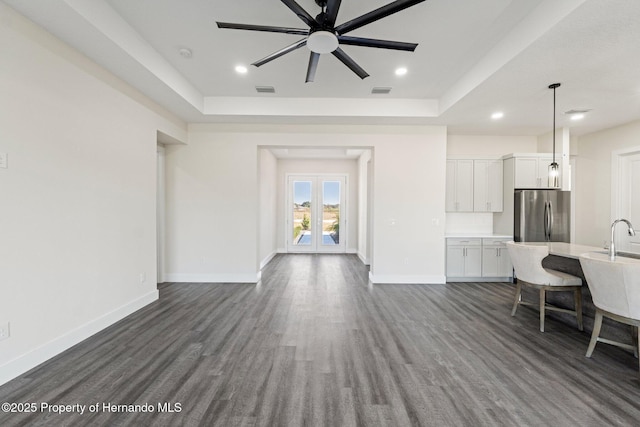 living room with french doors, dark hardwood / wood-style flooring, a raised ceiling, and sink