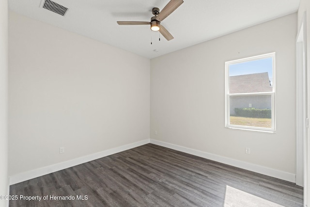 spare room with ceiling fan and dark hardwood / wood-style flooring