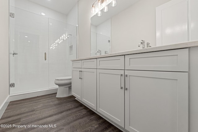 bathroom featuring walk in shower, wood-type flooring, toilet, and vanity