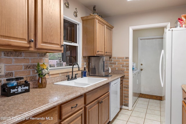 kitchen featuring sink, white appliances, light tile patterned floors, independent washer and dryer, and backsplash