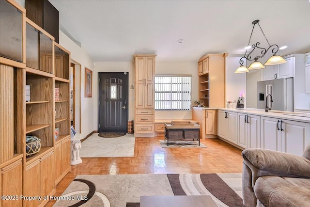 kitchen with light parquet flooring, sink, high end refrigerator, and decorative light fixtures