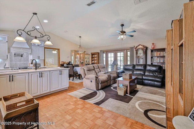 living room with french doors, sink, vaulted ceiling, ceiling fan, and light parquet floors