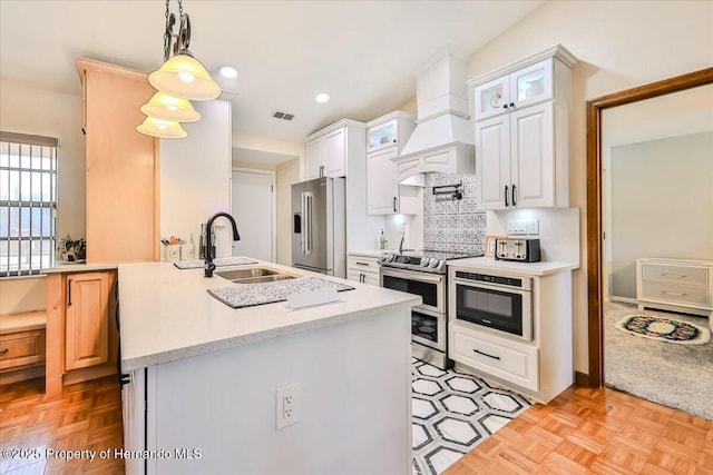 kitchen with premium range hood, sink, hanging light fixtures, appliances with stainless steel finishes, and white cabinets