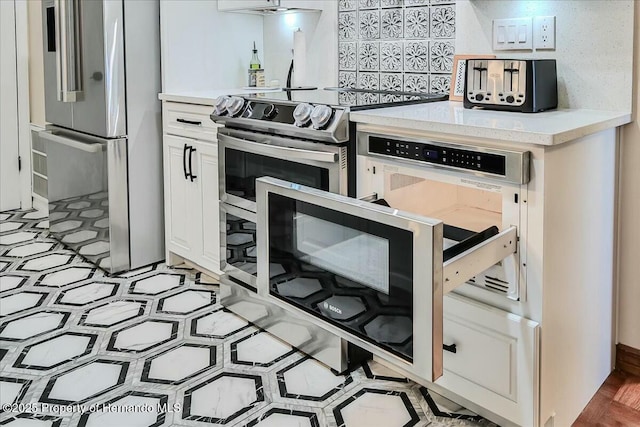 kitchen featuring stainless steel appliances and white cabinets