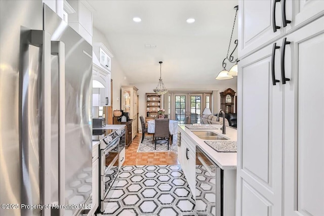 kitchen with white cabinetry, appliances with stainless steel finishes, sink, and pendant lighting