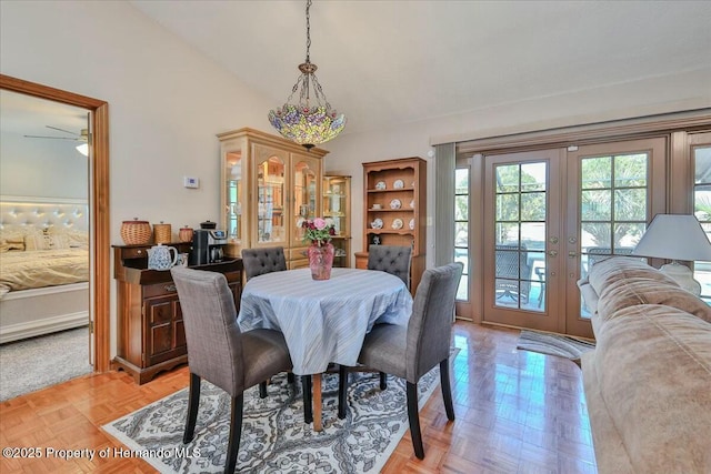 dining space featuring light parquet floors, high vaulted ceiling, and french doors