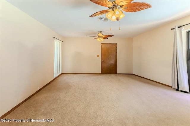 empty room with ceiling fan, plenty of natural light, and light carpet