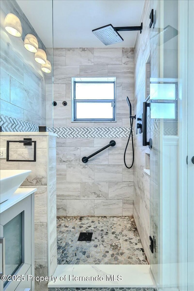 bathroom featuring vanity and tiled shower