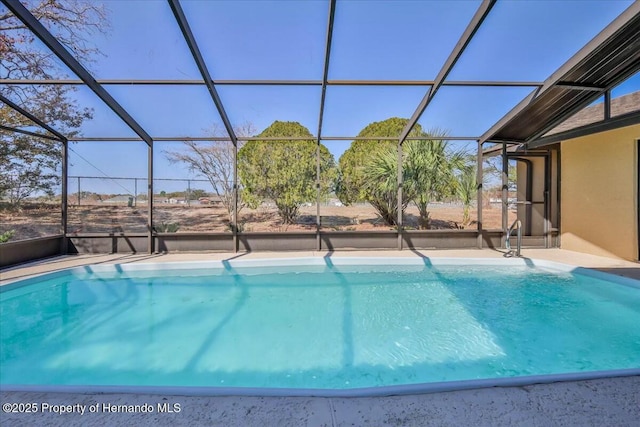 view of swimming pool featuring glass enclosure