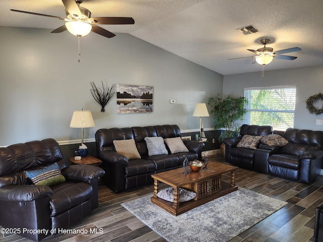 living room featuring ceiling fan, dark hardwood / wood-style flooring, vaulted ceiling, and a textured ceiling