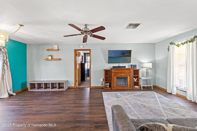 living room featuring dark wood-type flooring and ceiling fan