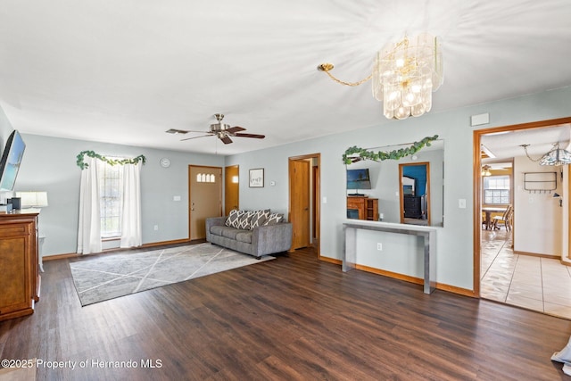 unfurnished living room with ceiling fan with notable chandelier and hardwood / wood-style floors