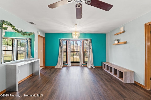 interior space with dark hardwood / wood-style floors, a wealth of natural light, and an inviting chandelier