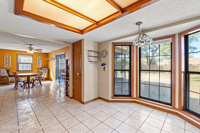 tiled dining space featuring ceiling fan and a textured ceiling