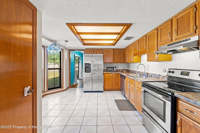 kitchen featuring light tile patterned flooring, sink, decorative backsplash, stainless steel appliances, and a textured ceiling