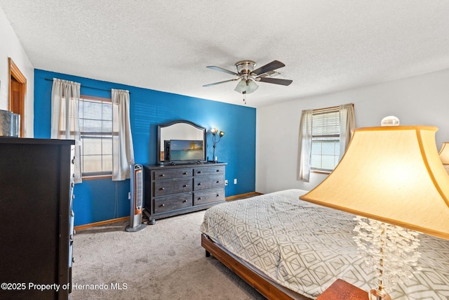 bedroom with ceiling fan, carpet floors, and a textured ceiling