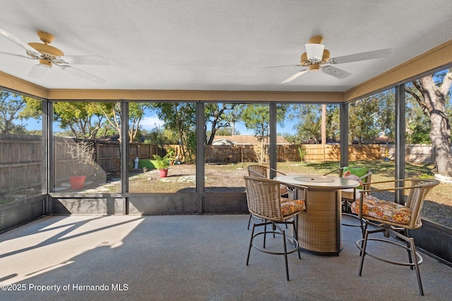 sunroom / solarium featuring plenty of natural light and ceiling fan