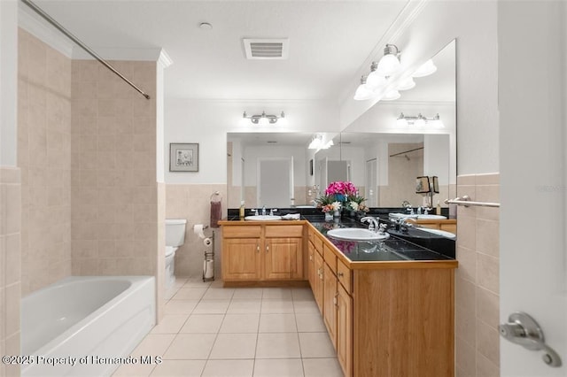 full bathroom with tile walls, tile patterned flooring, vanity, toilet, and tiled shower / bath