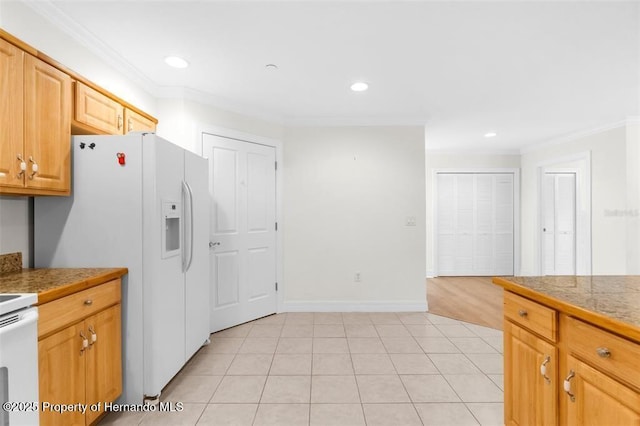 kitchen with light tile patterned flooring, white appliances, ornamental molding, and light brown cabinets