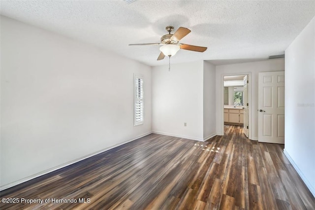 unfurnished room with ceiling fan, dark hardwood / wood-style floors, a textured ceiling, and a wealth of natural light