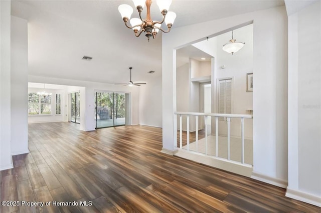 empty room featuring ceiling fan with notable chandelier and dark hardwood / wood-style floors