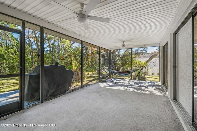 unfurnished sunroom featuring ceiling fan