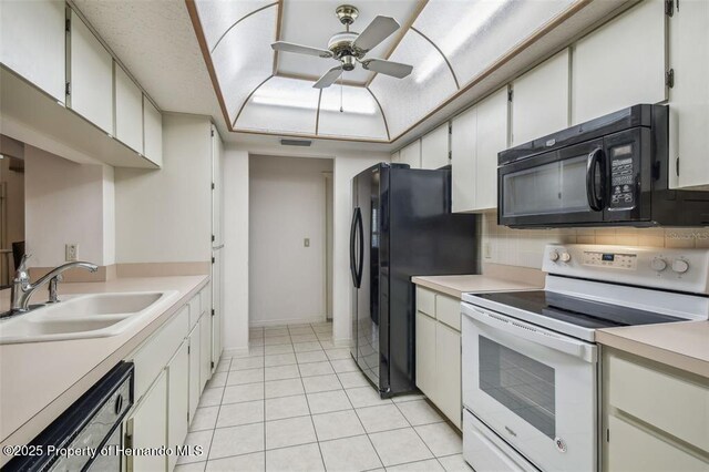 kitchen featuring sink, backsplash, black appliances, and white cabinets