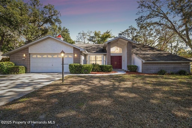 ranch-style house with a garage and a yard